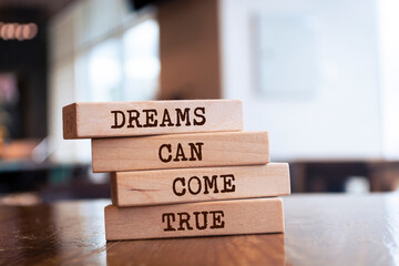 Wooden blocks with words 'Dreams can come true'.