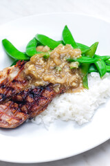 pork steak with onion sauce, green beans and rice