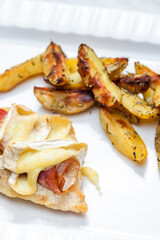 poultry meat grilled with parma ham and brie cheese served with roasted potatoes