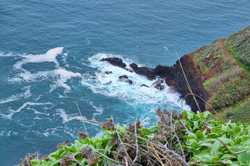 View from a height to the bright turquoise waves of the ocean.