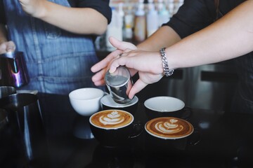 Barista making latte in coffee bar.