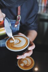 Fototapeta premium Barista making latte in coffee bar.