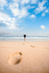 Stunning view a girl walking on the Cofete beach with her footprints on the sand in the foreground. Fuerteventura, Canary Islands. © Travel Wild