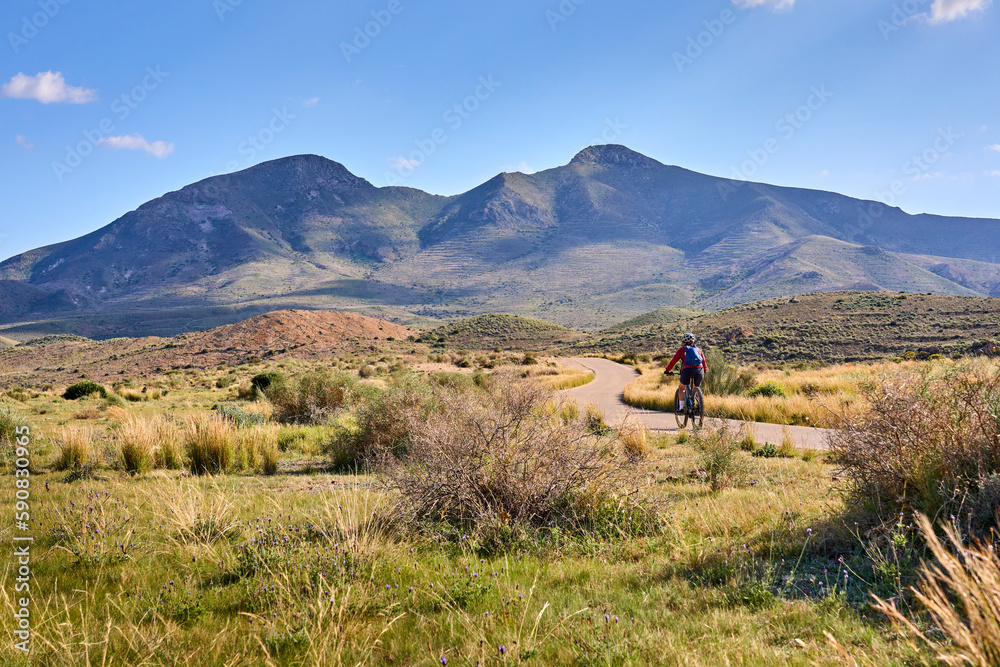 Wall mural nice senior woman cycling with her electric mountain bike in the volcanic nature park of cabo de gat