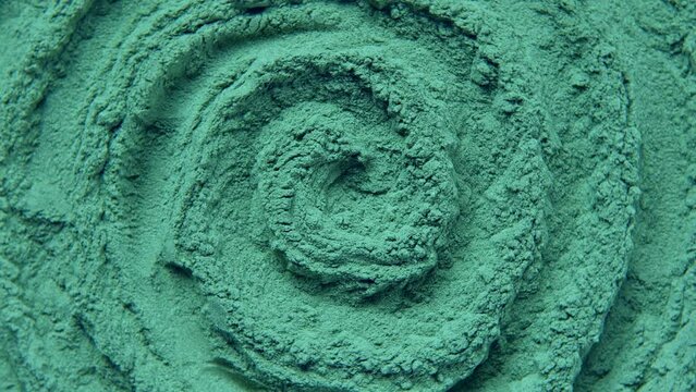 Chlorella or spirulina algae green powder is spinning, rotation. Dietary supplement to improve health. Seaweed super food. Healthy food background. Vitamins and minerals to diet. Detox. Closeup video
