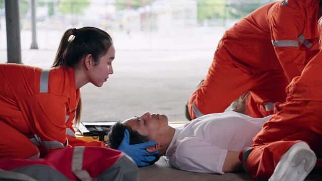 Group of Asian emergency medical technician (EMT) or paramedic team is holding manual stabilization of the head patients and wearing neck collar, Emergency medical services (EMS) nurses concept