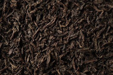 Background of black loose-leaf tea. Close up, top view