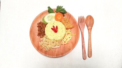 A plate of Turmeric Rice or Nasi Kuning, a traditional food from Indonesia. On a white background.