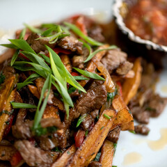 Thai vegetables and meat. Asian dish. close-up. White background. Soft focus. View from above.