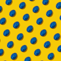 Pattern made with blue Easter Eggs on yellow Background. Creative Layout. Flat lay.