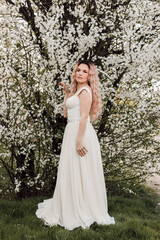 A beautiful woman in a spring garden near cherry blossoms. Flowering garden