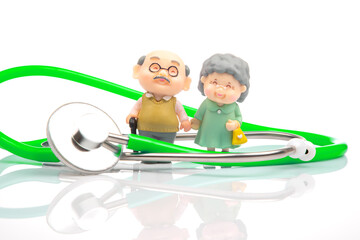 miniature people. Stethoscope and figurines of pensioners on a white background. The concept of health and disease prevention in the elderly