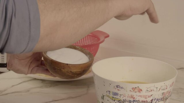 Cocinero echando sal sobre mezcla de huevo y patatas para tortilla espa&ntilde;ola tradicional