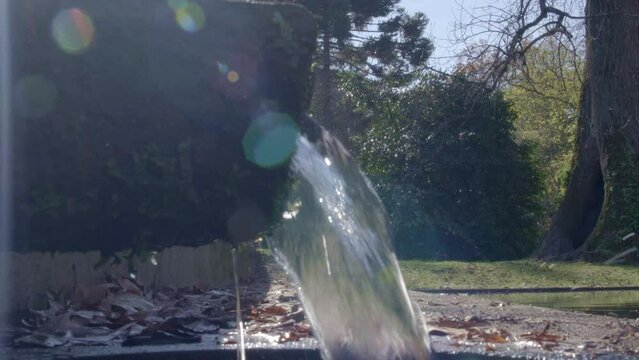 Chorro de agua iluminado por el sol con fondo natural