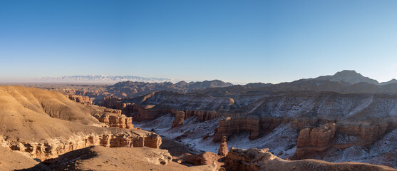 Fototapeta na wymiar Canyon in the foreground and mountains with blue skies in the background, panorama. High quality photo