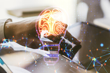Creative light bulb illustration with human brain and with finger presses on a digital tablet on background, future technology concept. Multiexposure