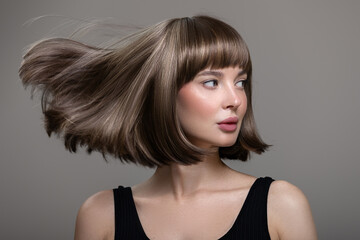 Portrait of beautiful fashion woman with bob hairstyle. Flying hairs up. Surf background