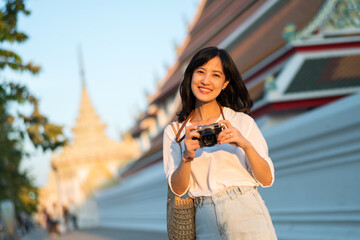Portrait of asian woman traveler using camera at street of Bangkok, Thailand. Asia summer tourism vacation concept