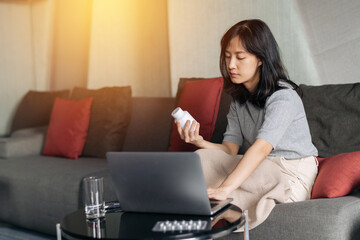 Sick asian woman with medicine having video call conference medical app in telehealth on laptop. Healthcare, technology and people concept