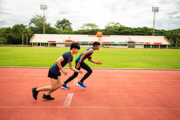 Two young Asian men athlete running competition with motion blur on the track in stadium