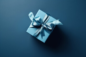 Gift box with satin ribbon and bow on blue background. Holiday gift with copy space. Birthday or Christmas present, flat lay, top view. Christmas giftbox concept. AI generated.