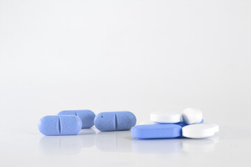 Assorted pills on a neutral background with light blue colors. Concept of pills used for male...
