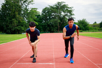 Obraz premium Two young Fit and confident Asian teenagers in starting position ready for running. Male athlete start a sprint