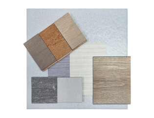 top view of interior material samples board contains ash vinyl flooring tile, stone ceramic tiles, interior fabric wallpapers, wooden laminated flooring isolated on background with clipping path.