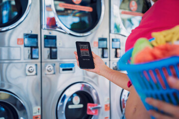 Young woman pays for laundry service using phone and banking application