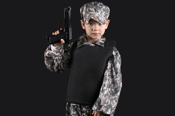 Cute little soldier with gun on black background
