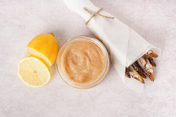 Jar with delicious caviar of capelin, lemon and smoked fish wrapped in parchment on white background