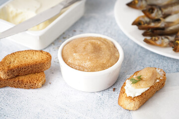 Bowl with delicious caviar of capelin and croutons on grey background