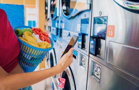 Young woman pays for laundry service using phone and banking application