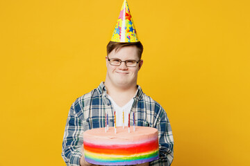 Young smiling man with down syndrome wear glasses casual clothes look camera hold in hand colourful...