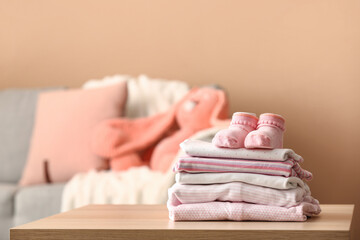 Stack of baby clothes and socks on table in room