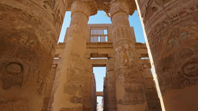 Karnak Temple in Luxor, Egypt. Camera moves between majestic columns with ancient Egyptian drawings. Gimbal high quality shot