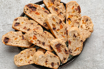 Plate with tasty biscotti cookies on grunge background, closeup