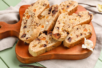 Wooden board with tasty biscotti cookies on table, closeup