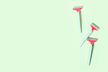 Set of safety razors on green background