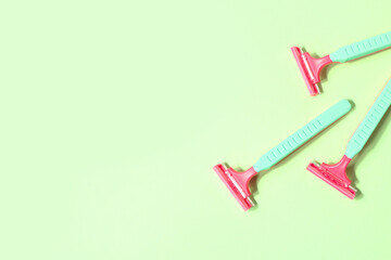 Set of safety razors on green background