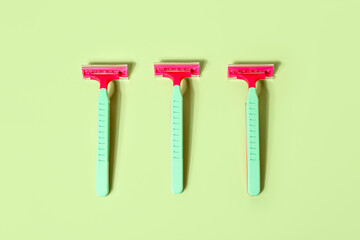 Set of safety razors on green background