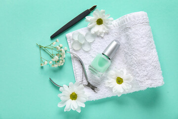 Composition with bottle of cuticle oil, towel, flowers and manicure instruments on color background