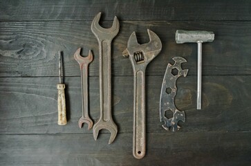 On a wooden background, carpentry and hand tools for work, wrenches, an old screwdriver and a pipe wrench.  Flat lay top view, close-up.  The concept of men's work.
