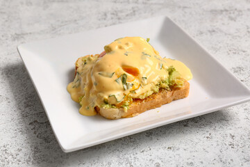 Plate with delicious egg Benedict on white grunge table