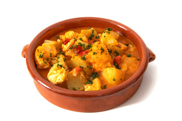 Potato stew with cod, served in a clay bowl. Isolated on white background. Spanish food concept.