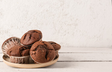 Plate with tasty chocolate cupcakes on table