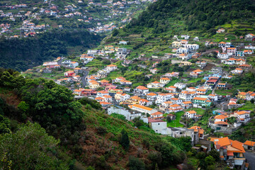 Fototapeta na wymiar Madeira. Vereda da Boca do Risco. View of Machico village, located between green hills. Madeira Island, Portugal.