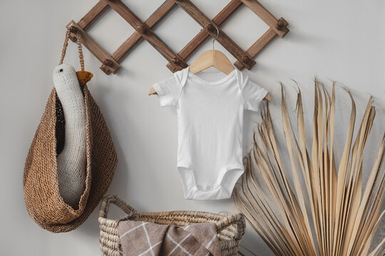 Minimalist white baby short sleeve bodysuit mockup for presentation cute sublimation designs. Minimalistic photos of romper for toddlers in scandinavian boho interior with minimalistic decoration