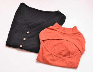 Black t-shirt and another orange one with an opening on the chest on a white background