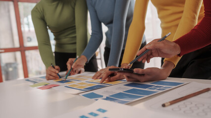 Group of ui ux developer brainstorming website wireframe mobile interface design on desk table.